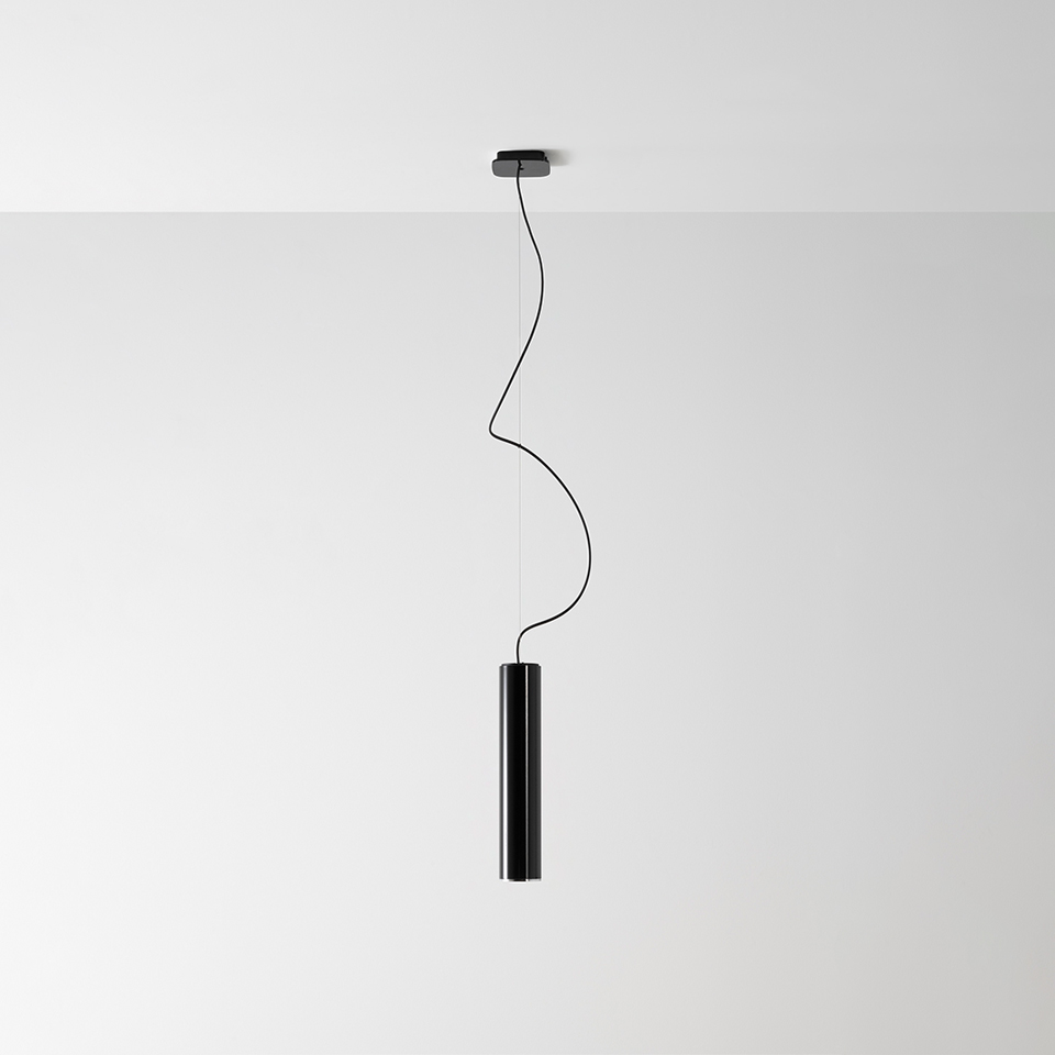 Artemide Ilio pendant lamp: sleek black cylindrical tube suspended from ceiling by a sinuous black cable