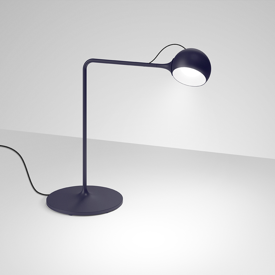 Lampada da tavolo Artemide Ixa blu scuro, con base rotonda, braccio curvo e testa sferica LED orientabile che emette luce concentrata