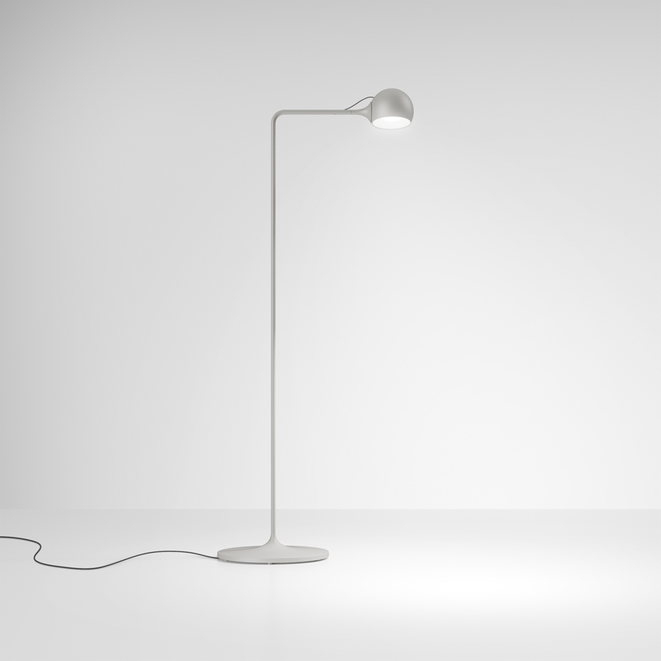 Lampada da terra Artemide Ixa bianca, con fusto sottile curvo, base circolare e testa sferica LED orientabile