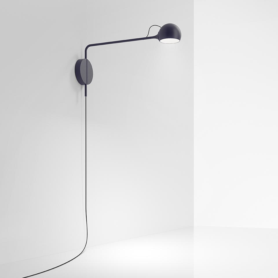 Lampada da parete Artemide Ixa blu scuro, con braccio lungo regolabile, testa sferica e cavo a vista lungo la parete