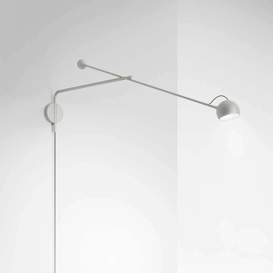 Lampada da parete Artemide Ixa bianca, con lungo braccio regolabile e piccola testa sferica orientabile, montata su parete ad angolo