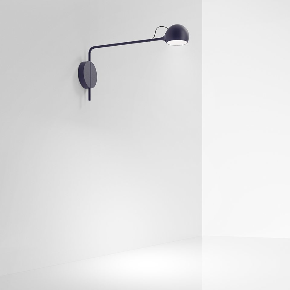 Lampada da parete Artemide Ixa blu scuro, con braccio lungo regolabile e testa sferica orientabile, montata su base circolare a parete