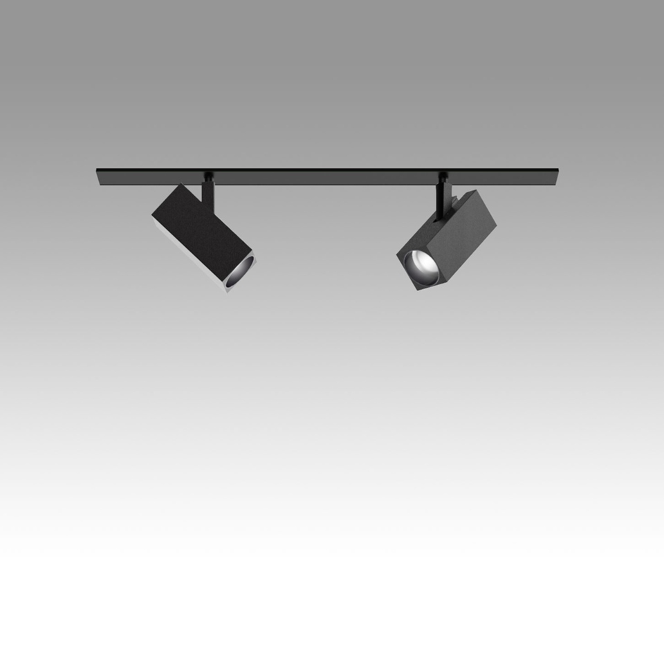 Artemide Katà Métron: due faretti quadrati neri orientabili su binario a soffitto, uno acceso con luce LED calda