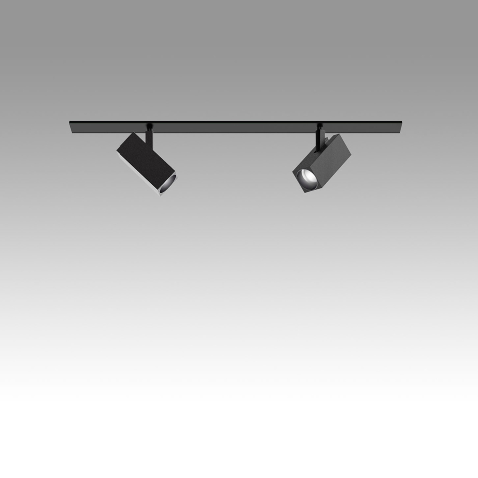 Sistema binario Artemide Katà Métron nero con due faretti quadrati orientabili su binario a soffitto, uno illuminato