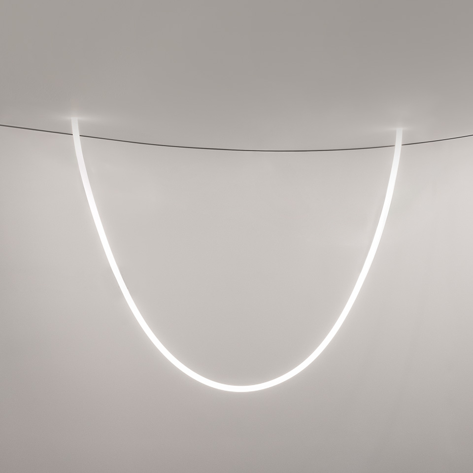 Lampada a sospensione Artemide La Linea: tubo LED flessibile luminoso sospeso al soffitto in un'elegante curva a U