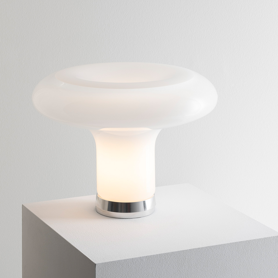 Lampada da tavolo Artemide Lesbo con diffusore in vetro soffiato opalino bianco a forma di fungo e base in cromo lucido su superficie bianca