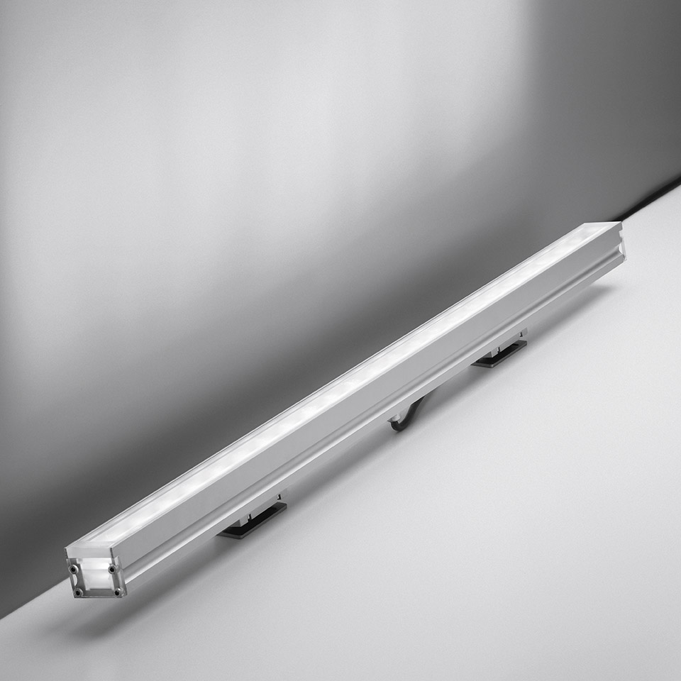 Artemide LineaLed Wallwasher: sottile barra LED allungata in alluminio con striscia luminosa diffusa e staffe di montaggio, vista angolata