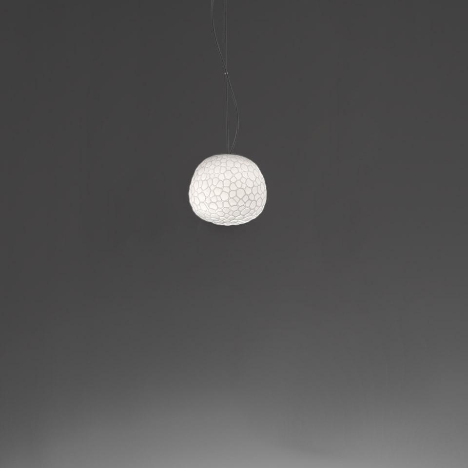 Lampada a sospensione Artemide Meteorite: diffusore sferico bianco con texture cellulare organica, sospeso da sottili cavi