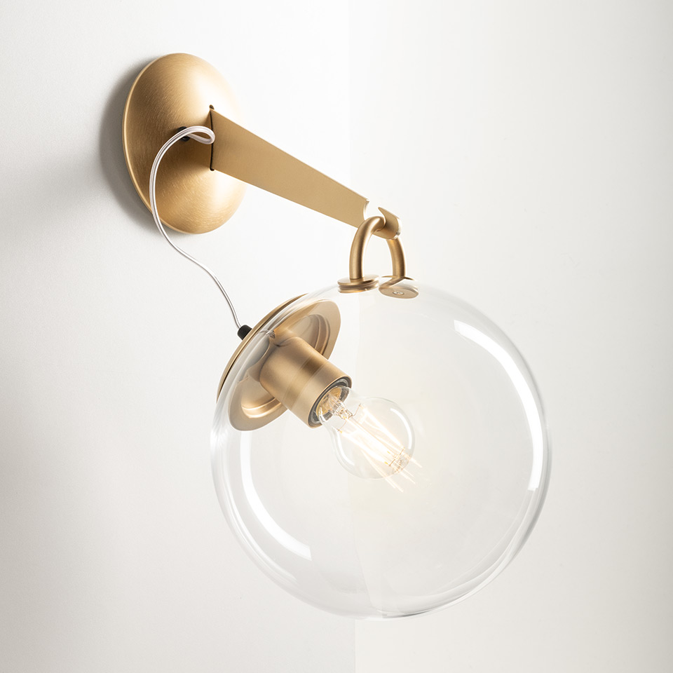 Applique Artemide Miconos: braccio e rosone in oro spazzolato con globo in vetro trasparente e lampadina Edison vintage