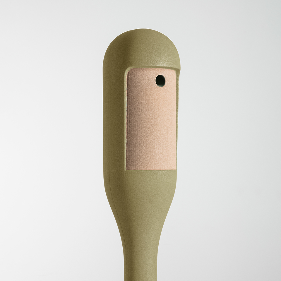Dettaglio sommità lampada da terra Artemide Needoo: corpo verde oliva con testa arrotondata e patch in pelle rettangolare con unico bottone nero