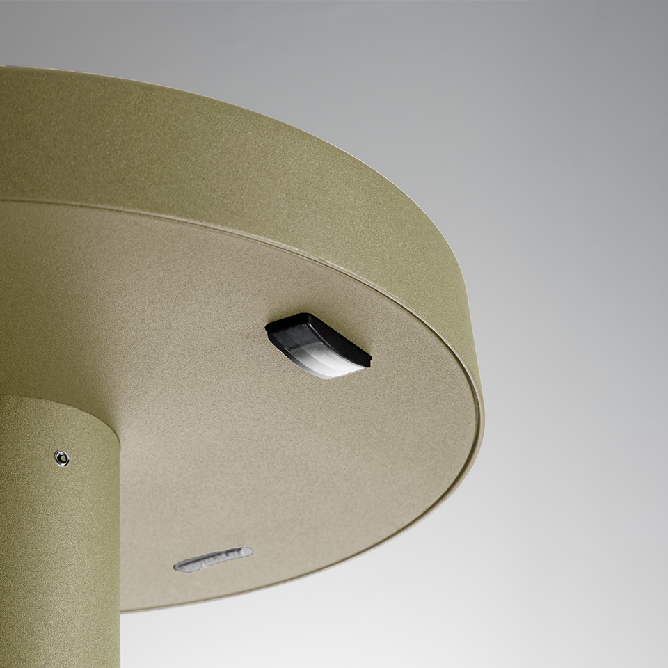 Primo piano della base della lampada da esterno Artemide Needoo in finitura oro, con modulo LED nero e fessura di ventilazione sull'alloggiamento circolare