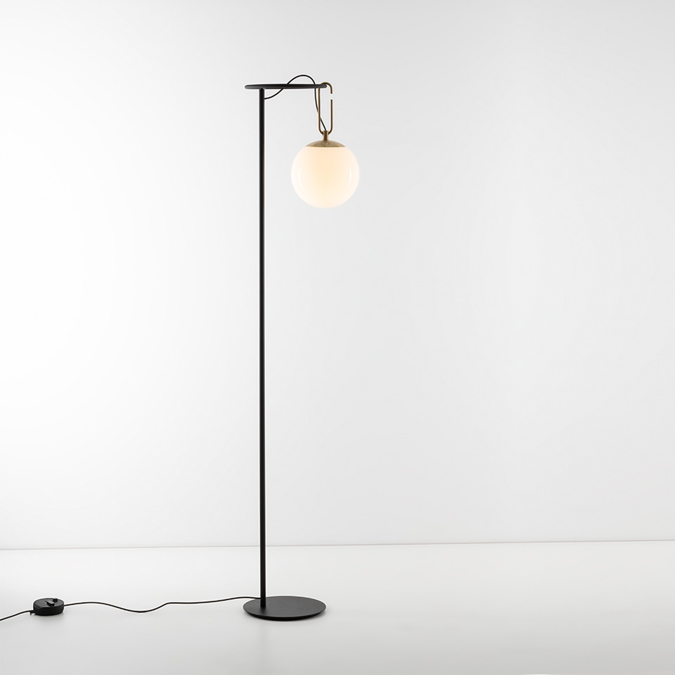 Lampada da terra Artemide NH Terra: alto fusto in metallo nero con base rotonda, gancio in ottone che sostiene un diffusore globo in vetro bianco opalino