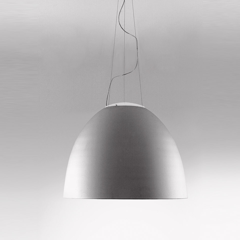 Lampada a sospensione Artemide Nur 1618 con ampio paralume a cupola in alluminio opaco, sospesa da sottili cavi su sfondo neutro