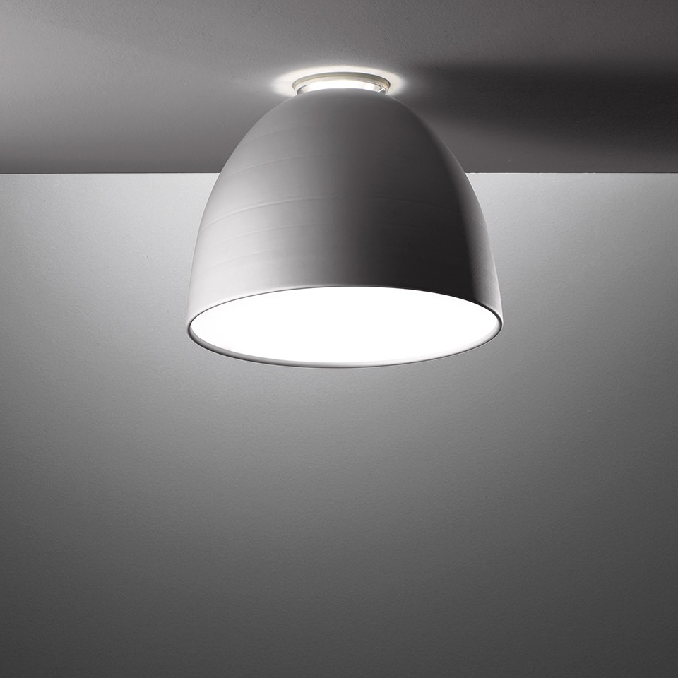 Artemide Nur Mini ceiling lamp, dome-shaped aluminium shade in grey, flush-mounted on ceiling with warm downward light