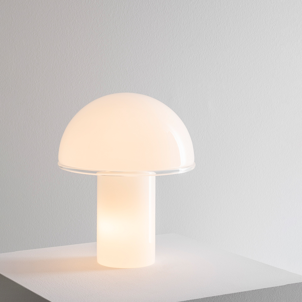 Artemide Onfale table lamp: mushroom-shaped opal white glass diffuser with cylindrical base, emitting warm soft light