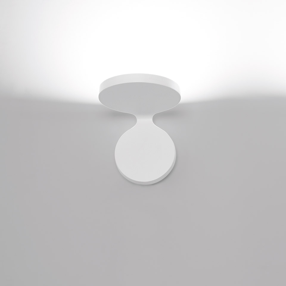 Faretto da soffitto Artemide Rea in bianco, con testa circolare orientabile montata su base rotonda, proietta luce verso l'alto.