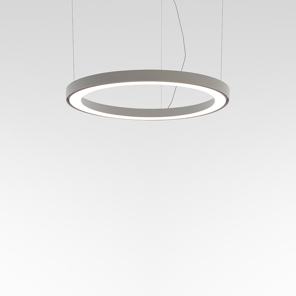 Lampada a sospensione Artemide Ripple: corpo circolare ad anello con LED in grigio, che emette luce diffusa lungo il bordo interno, sospesa da sottili cavi