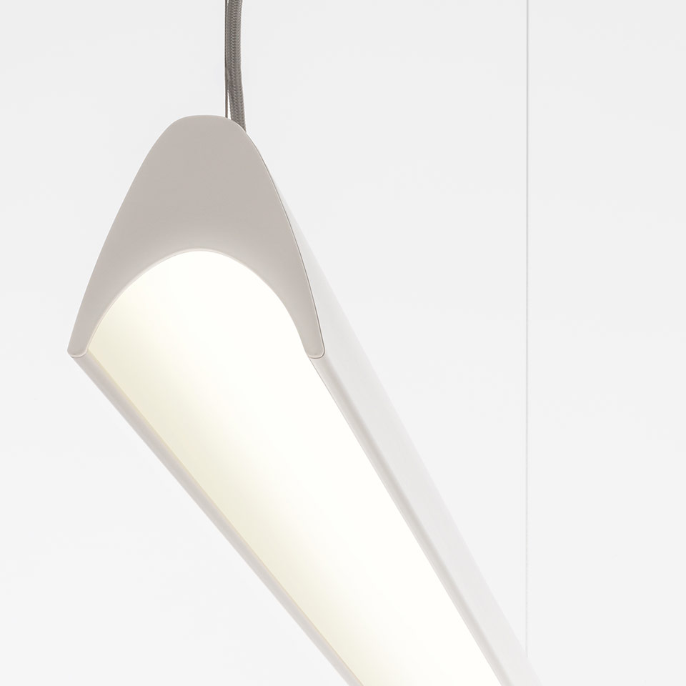 Artemide Series Y pendant lamp: white elongated conical shade angled downward, emitting warm diffused light from its open end