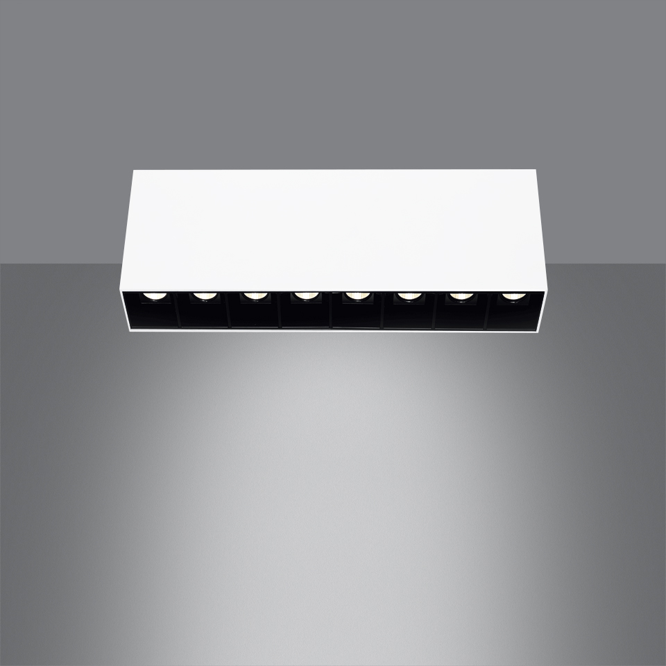 Artemide Sharp SMD ceiling light: white rectangular fixture with 7 black recessed LED spots casting a focused downward beam