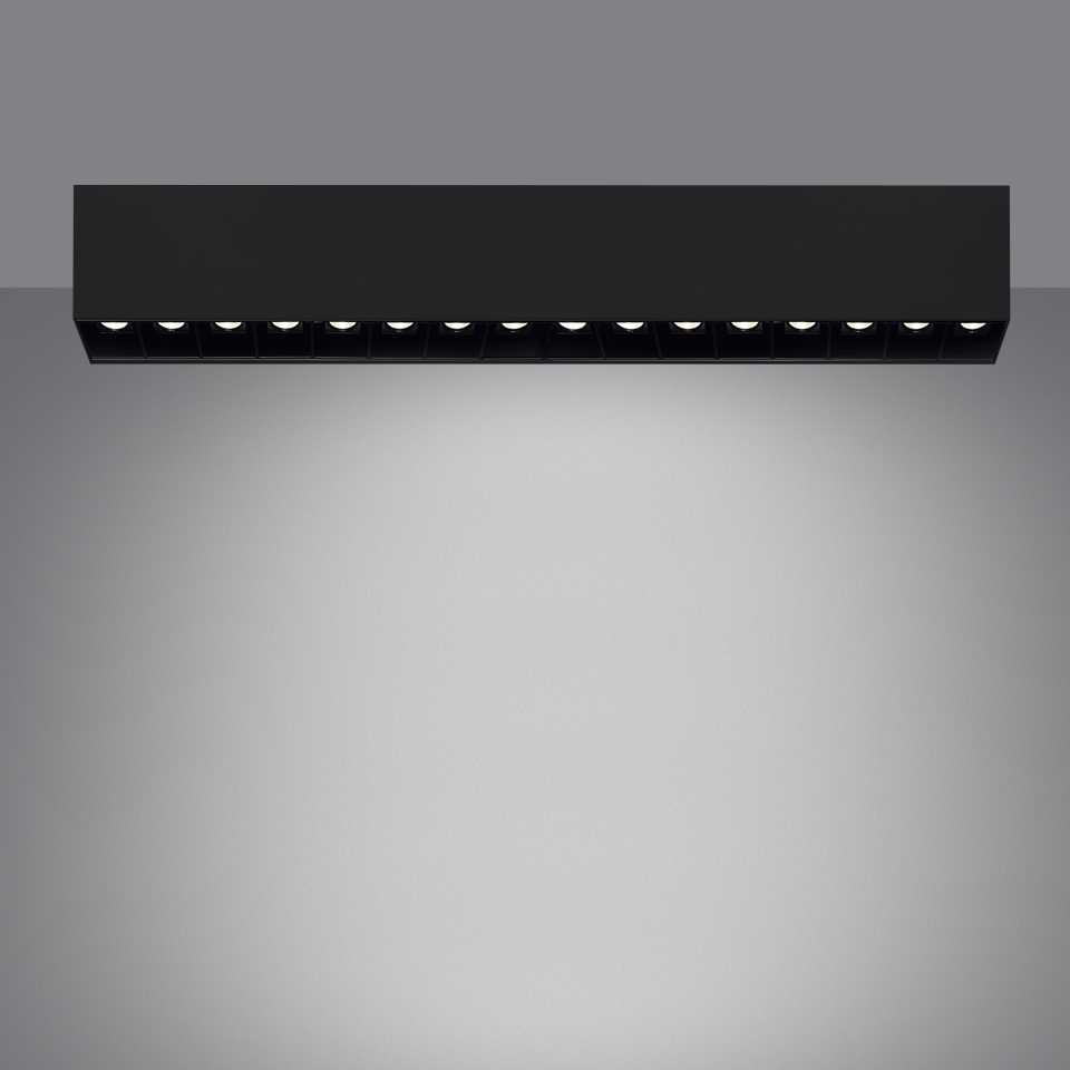 Artemide Sharp SMD ceiling light in black, featuring a linear array of 12 LED spotlights emitting a focused downward beam.