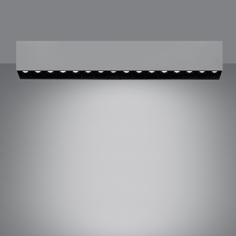 Artemide Sharp SMD ceiling light: rectangular white housing with 12 black recessed LED spotlights emitting focused downward beam