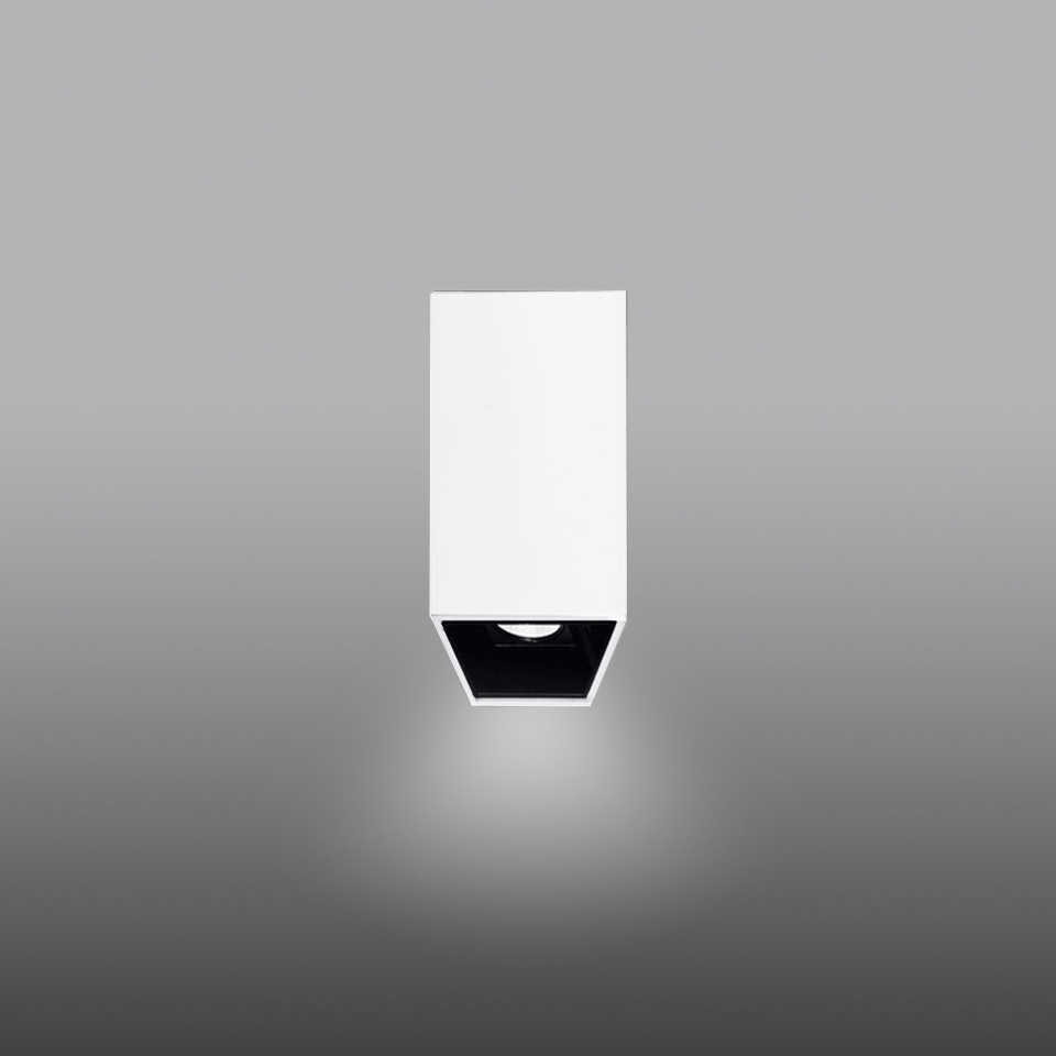 Artemide Sharp SMD ceiling spotlight: compact rectangular white body with black recessed LED source, emitting focused downward light.