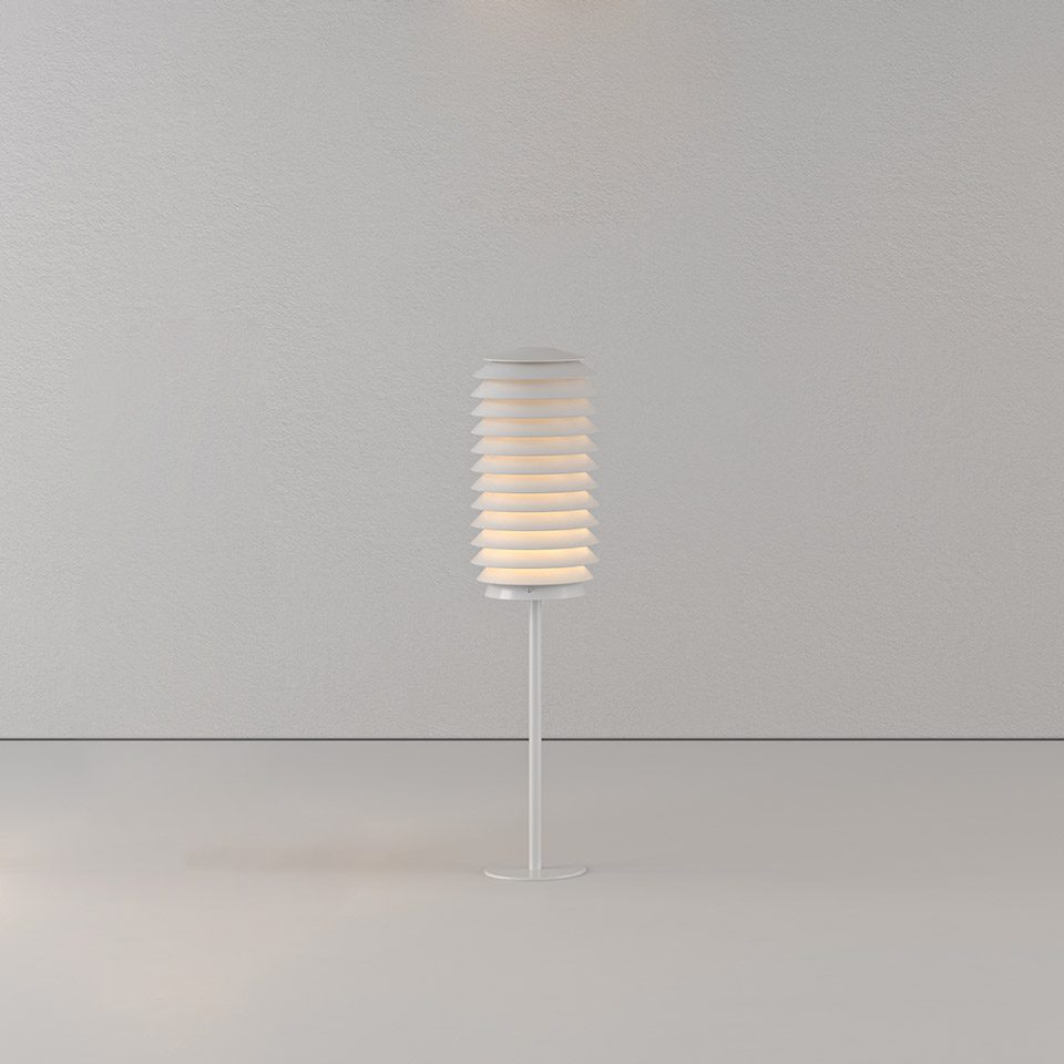 Lampada da tavolo Artemide Slicing: paralume cilindrico bianco con lamelle orizzontali sovrapposte su base a stelo sottile, emette luce diffusa calda