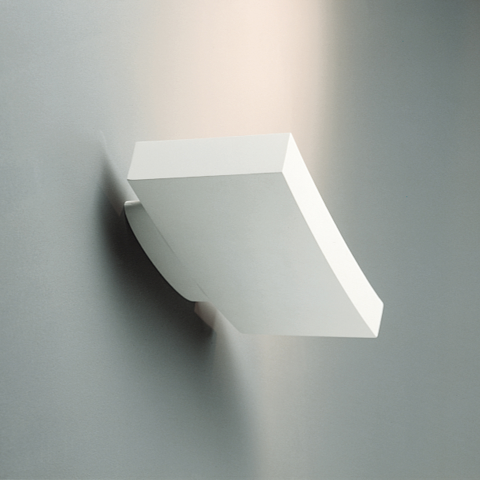Artemide Surf Parete wall lamp in white, with curved diffuser casting warm upward light against a grey wall
