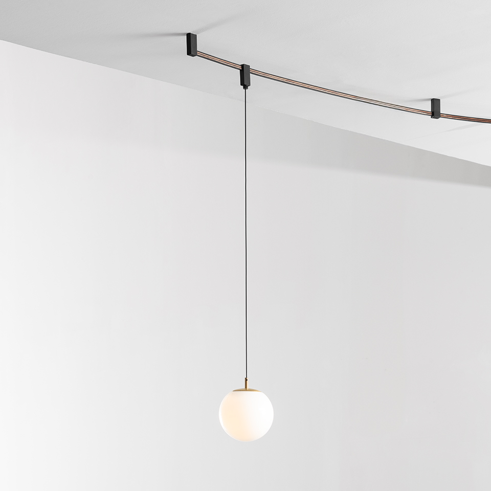 Lampada a sospensione Artemide Sylt: sfera in vetro bianco opalino appesa a un sottile cavo nero su sistema a binario a soffitto