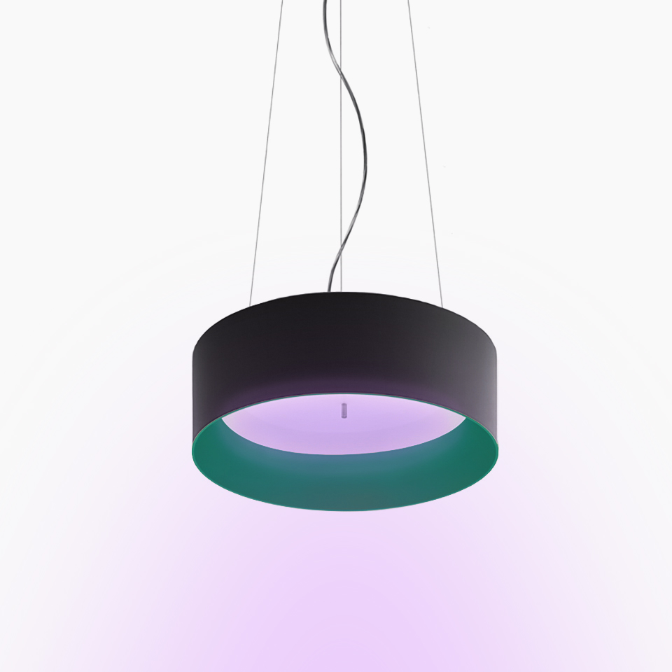 Artemide Tagora Sospensione 570: lampada a sospensione cilindrica nera con diffusore interno verde che emette luce viola tenue, sospesa da cavi in acciaio