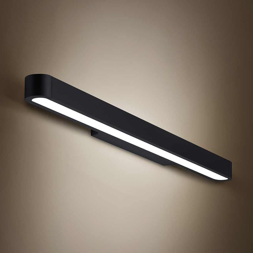 Artemide Talo wall lamp: elongated black LED fixture with rounded edges emitting warm white light along its full length
