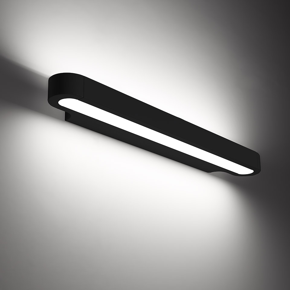 Talo wall lamp by Artemide: elongated black fixture with diffused LED strip emitting upward and downward light on wall