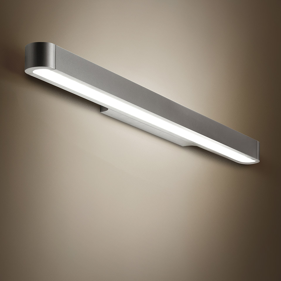 Artemide Talo wall lamp: sleek elongated aluminum bar with integrated LED strip, mounted diagonally on a warm-toned wall