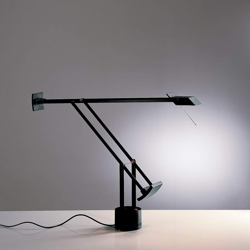 Lampada da tavolo Artemide Tizio in nero, con braccio controbilanciato, testa alogena orientabile e base minimalista su superficie bianca