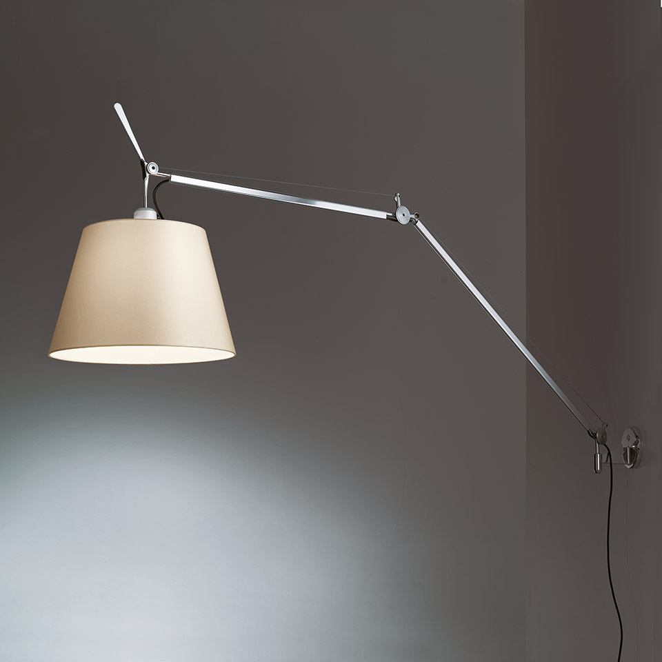 Lampada da parete Artemide Tolomeo Mega Parete con braccio in alluminio regolabile e paralume in tessuto beige, montata su parete grigia