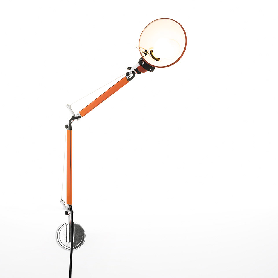 Lampada da parete Artemide Tolomeo Micro Parete arancione, con braccio articolato regolabile e paralume riflettore circolare, montata su staffa a muro cromata