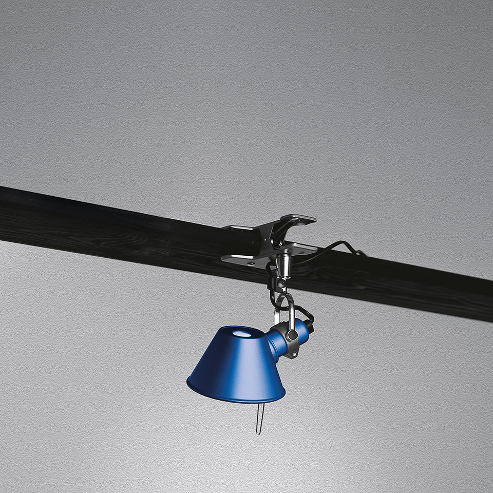 Lampada a pinza Artemide Tolomeo Pinza in blu, agganciata a una guida scura a soffitto, con paralume conico orientabile