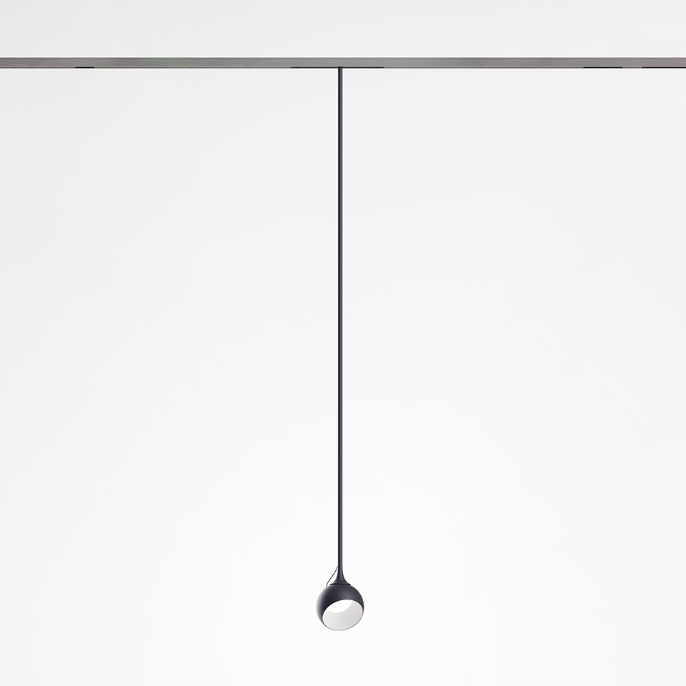 Artemide Turn Around System: faretto a sospensione scuro con testa a goccia appeso a binario a soffitto tramite sottile cavo nero