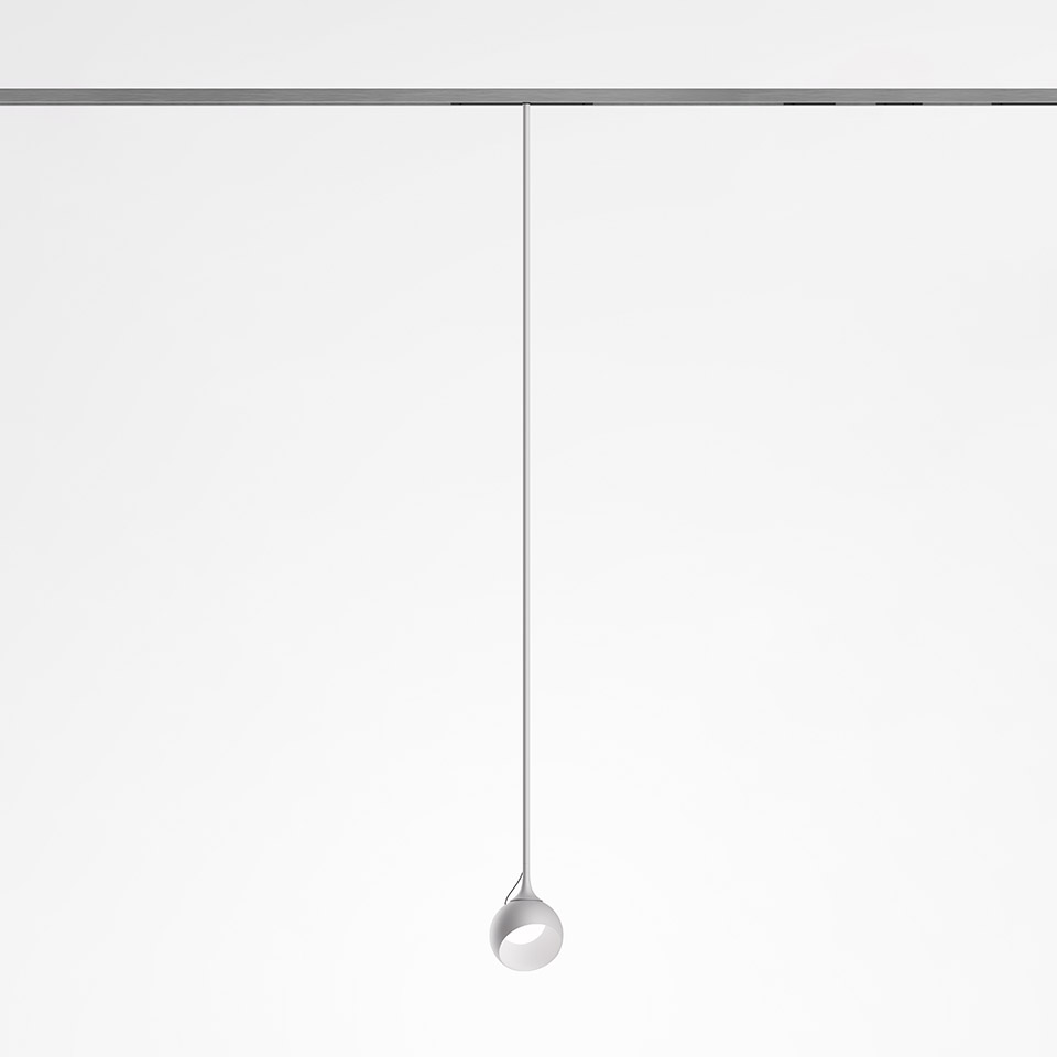 Artemide Turn Around System: lampada a sospensione minimalista con piccola testa sferica bianca sospesa da un filo sottile su binario a soffitto