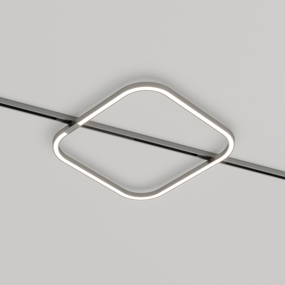 Artemide Turn Around System: lampada da soffitto LED quadrata con angoli arrotondati, montata in diagonale su binario a soffitto, emette luce bianca calda