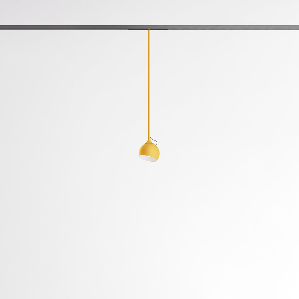 Artemide Turn Around System: lampada a sospensione gialla con paralume a cupola appesa a binario a soffitto tramite cavo giallo coordinato