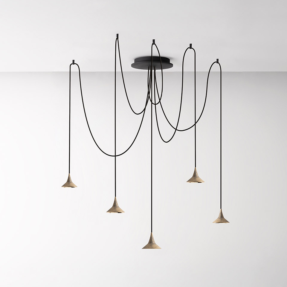 Lampadario Artemide Unterlinden: cinque pendenti conici in finitura naturale su cavi neri drappeggiati da un'unica rosetta nera a soffitto