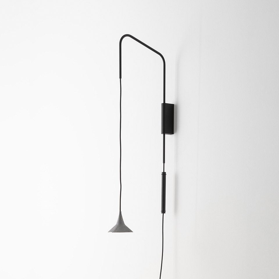 Lampada da parete Artemide Unterlinden: staffa a braccio nero orientabile con cavo regolabile e piccolo paralume conico grigio a sospensione