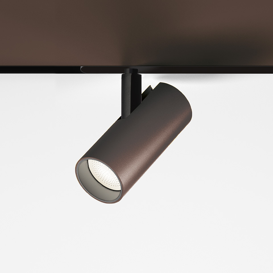 Faretto da binario magnetico Artemide Vector in bronzo scuro, corpo cilindrico con ottica LED, montato su binario magnetico nero