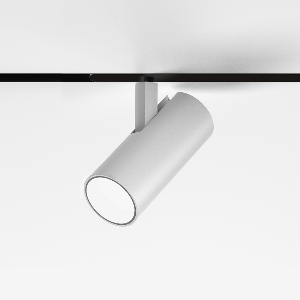 Faretto da binario cilindrico bianco Artemide Vector Magnetic, orientabile su binario magnetico nero, inclinato verso il basso per illuminazione direzionale