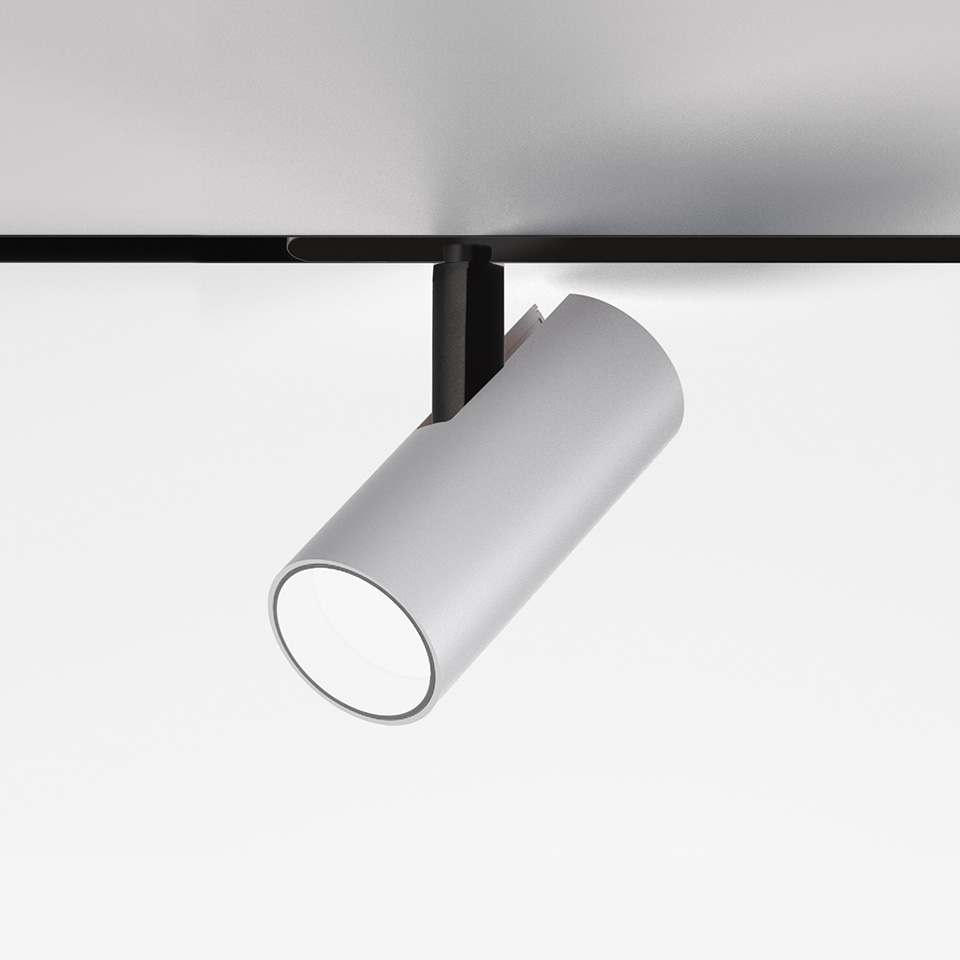 Faretto da binario magnetico Artemide Vector Magnetic: corpo cilindrico bianco a LED montato su binario magnetico nero, inclinato verso il basso