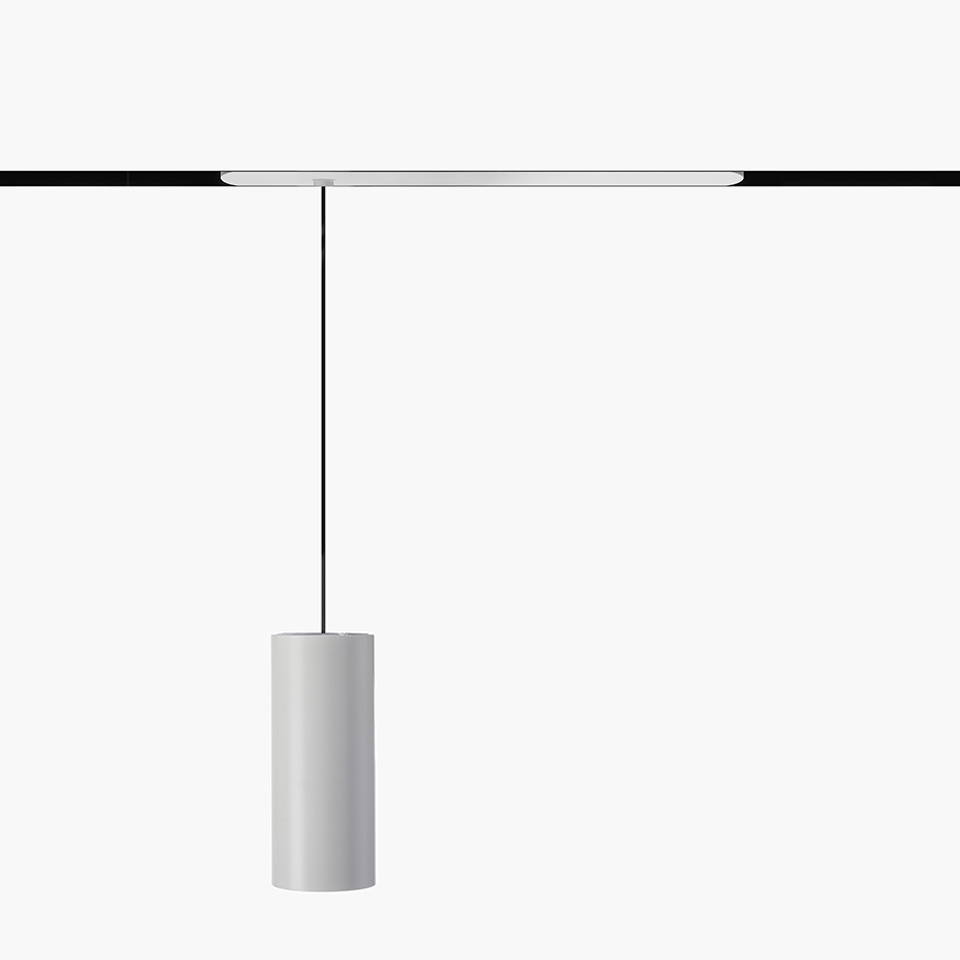 Artemide Vector Pendant Magnetic: cylindrical white pendant lamp suspended by black cable from a magnetic track rail