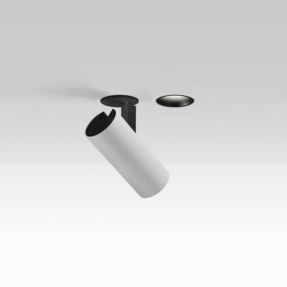 Faretto da incasso Artemide Vector: corpo cilindrico bianco inclinato verso il basso con bordo nero, mostrato con rosone separato a filo soffitto