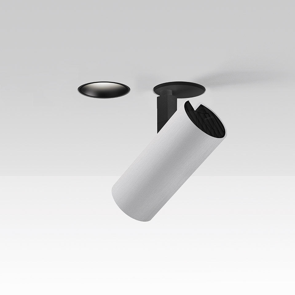 Faretto da incasso Artemide Vector: corpo cilindrico bianco orientabile che emerge da un supporto nero a incasso a soffitto, inclinato