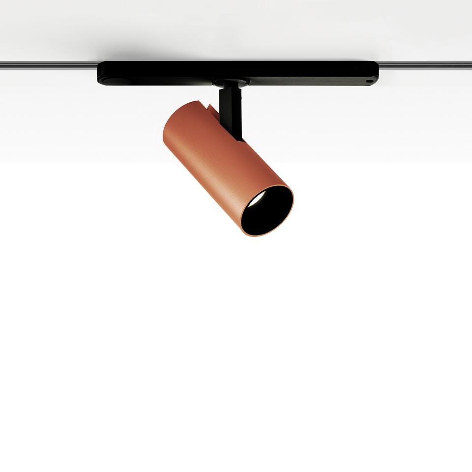 Faretto Artemide Vector Track 230V color terracotta, corpo cilindrico inclinato su supporto a binario nero per illuminazione direzionale